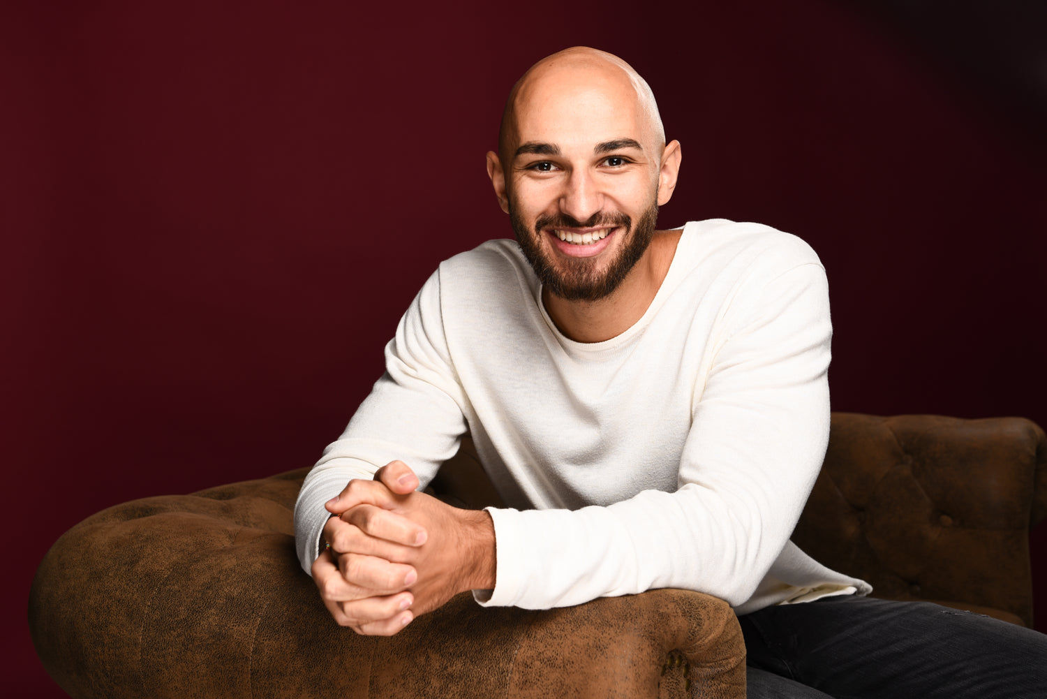Jonas Shahin Gründer von KOMM KLAR DIGGA Portraitfoto angelehnt sitzend auf einer Couch